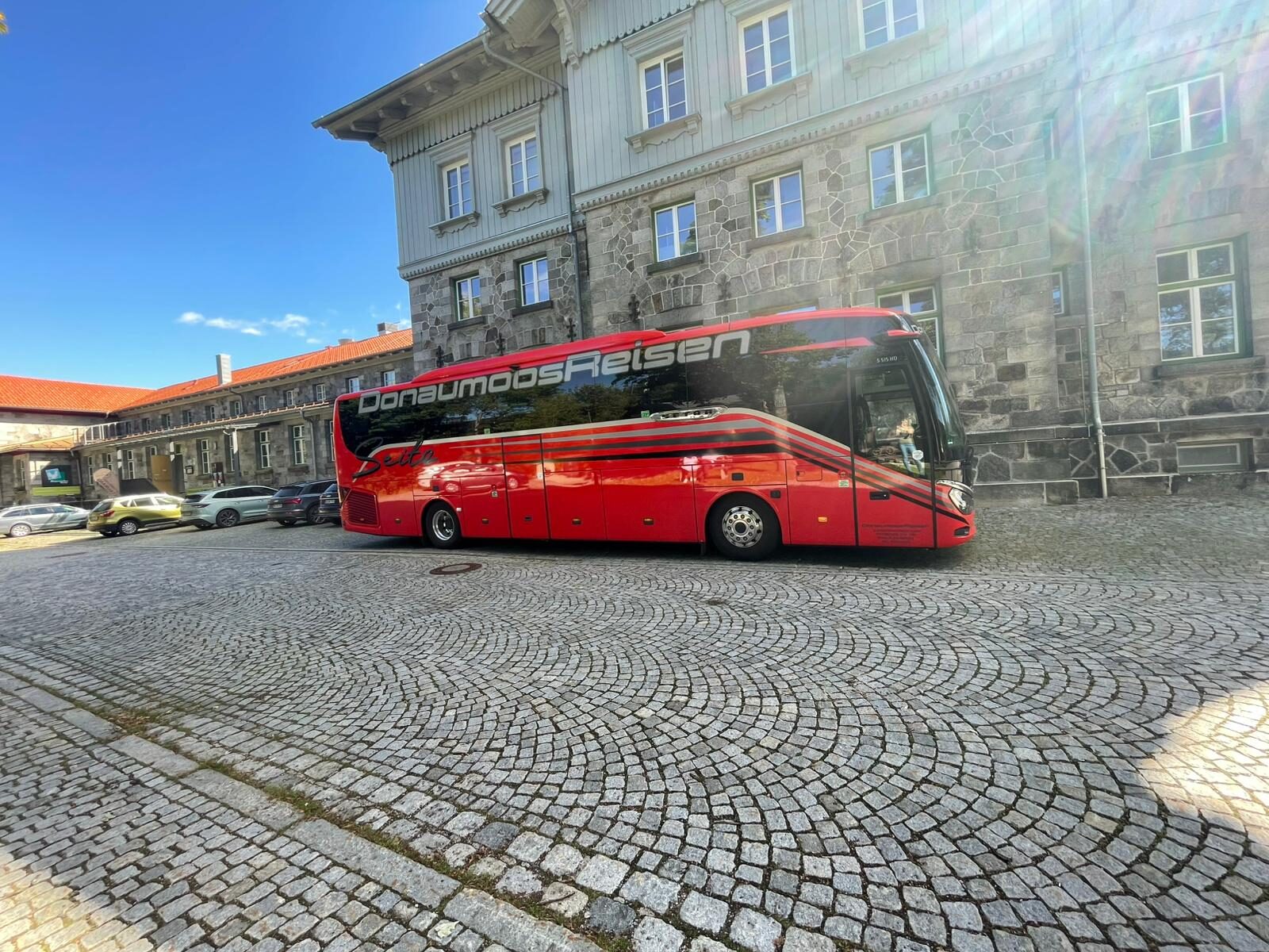 Donaumoos Reisen Setra-Reisebus auf gepflastertem Innenhof vor historischem bayerischem Anwesen